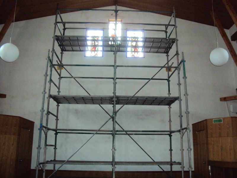 ステンドグラスにロールスクリーンを取付ける工事を行っています。天井まで６ｍ以上ある為、ステージ足場を組み施工します。