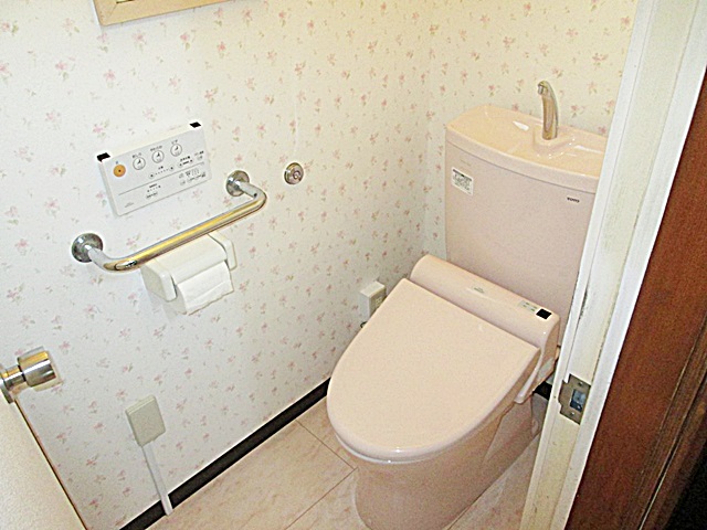 トイレは床に耐水フロアーを張り、壁をクロス仕上げとしました。壁の花柄とピンクのトイレで、可愛らしく温かみのある空間になりました。