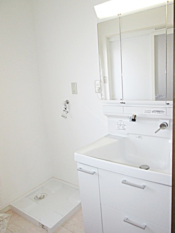 新しい洗面化粧台は、３面鏡と大きな洗面ボールで使い易くなっています。壁のクロスもホワイトを基調に明るい空間となりました。