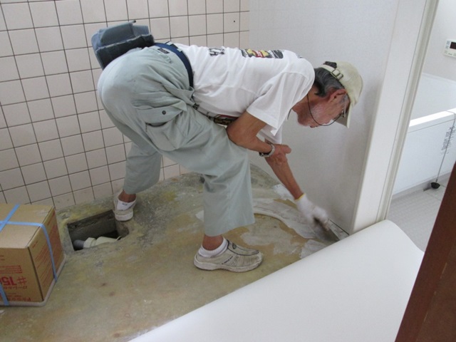 洗面所床のクッションフロアーを貼っている所です。白のり（接着剤）をヘラで全体に薄く塗り接着します。