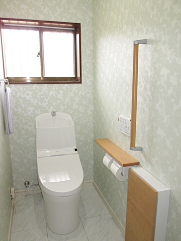 母屋のトイレは淡いグリーン系のクロスで、爽やかな個室に生まれ変わりました。手すりも取り付けて安全性にも配慮しました。